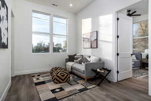 Living area featuring dark hardwood / wood-style flooring, vaulted ceiling, and ceiling fan