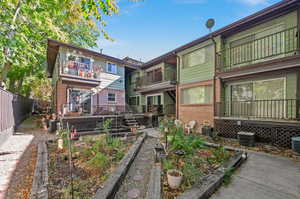 Back of property with cooling unit and a balcony