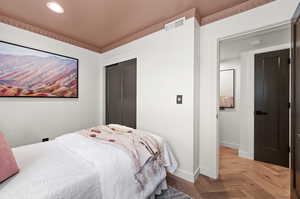 Bedroom with a closet and light parquet flooring