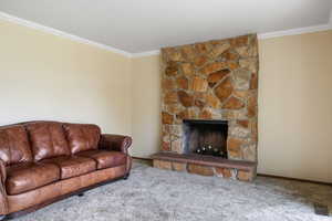 Carpeted living room featuring crownmolding and a fireplace