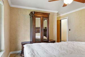 Primary Bedroom with ceiling fan and crown molding