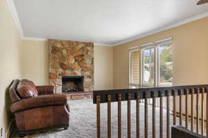 Living room with crown molding and a fireplace