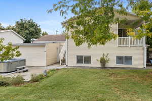 Back of house featuring a hot tub, a patio, shed, and a yard