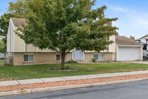 View of front of home featuring a front yard and a garage