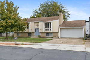 Bi-level home with a front yard and a garage