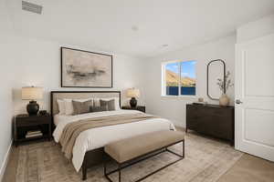 Bedroom with baseboards, light colored carpet, and visible vents