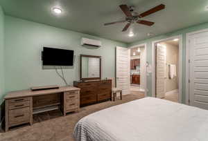 Bedroom featuring carpet, a wall unit AC, a textured ceiling, and ceiling fan