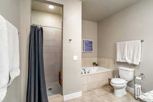 Bathroom featuring independent shower and bath, a textured ceiling, toilet, and tile patterned floors