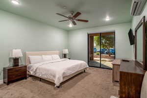 Bedroom with light colored carpet, access to outside, an AC wall unit, and ceiling fan