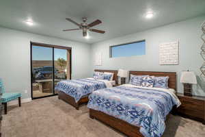 Carpeted bedroom featuring a textured ceiling, access to exterior, and ceiling fan