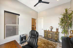 Office area featuring lofted ceiling, heating unit, and ceiling fan