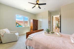 Carpeted bedroom featuring ceiling fan