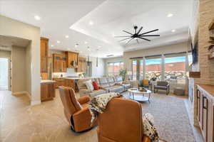 Living room featuring a tray ceiling and ceiling fan