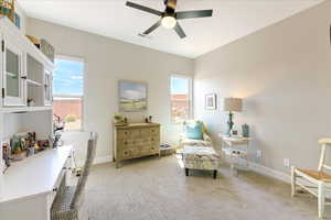 Sitting room with ceiling fan, plenty of natural light, and light colored carpet