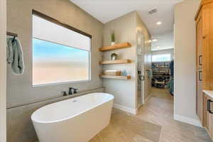 Bathroom with a wealth of natural light, vanity, and shower with separate bathtub