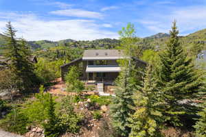 View of front of property with a mountain view and a forest view