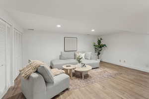 Living room with recessed lighting, wood finished floors, and baseboards