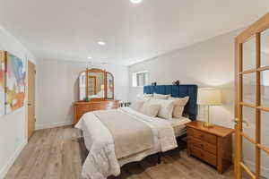 Bedroom featuring wood finished floors, recessed lighting, and baseboards