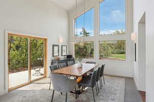 Dining room featuring high vaulted ceiling, healthy amount of natural light, and baseboards