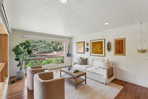 Living room with baseboards, wood finished floors, and recessed lighting