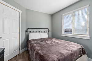 Bedroom with dark hardwood / wood-style flooring