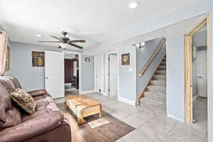 Living room featuring ceiling fan and a textured ceiling