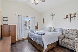 Bedroom featuring dark wood-type flooring, ceiling fan, and vaulted ceiling