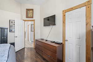 Bedroom with dark hardwood / wood-style flooring