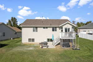 Rear view of house with a wooden deck, a yard, and a patio area