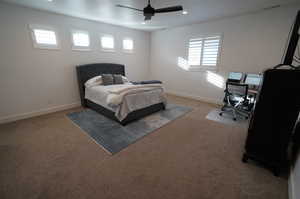 Carpeted bedroom featuring ceiling fan