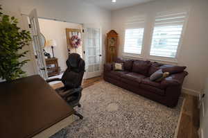 Home office with french doors and hardwood / wood-style floors