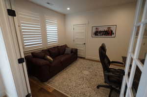 Home office with dark hardwood / wood-style floors