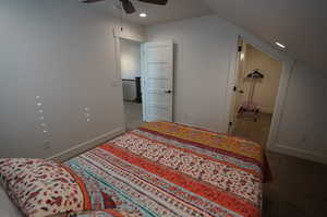 Carpeted bedroom featuring lofted ceiling and ceiling fan