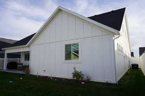 View of side of property featuring a patio, a yard, and central AC unit