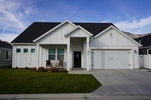 Modern farmhouse style home with a front lawn and a garage