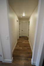 Hallway with dark hardwood / wood-style flooring