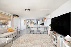 Living room featuring an AC wall unit and light wood-type flooring