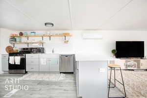 Kitchen featuring tasteful backsplash, appliances with stainless steel finishes, sink, light hardwood / wood-style floors, and a breakfast bar