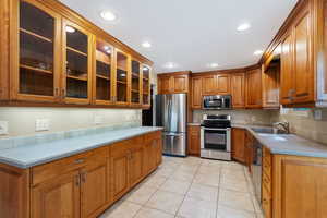 Kitchen with sink, appliances with stainless steel finishes, and light tile patterned floors