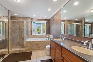 Full bathroom featuring plus walk in shower, toilet, vanity, ornamental molding, and tile patterned flooring