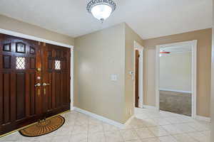 Tiled entryway with a textured ceiling