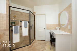 Bathroom featuring vanity, walk in shower, tile patterned floors, and tile walls