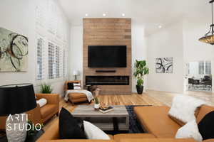 Living room with a large gas fireplace with ambient lighting and wood-type flooring