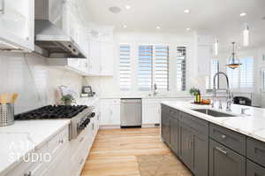 Kitchen featuring a healthy amount of sunlight, pendant lighting, and white cabinets