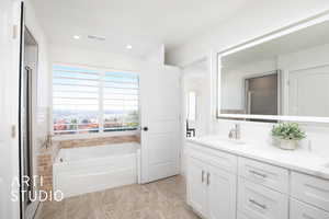 Bathroom with vanity and a tub to relax in