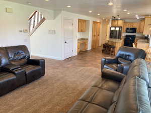 Living room with light colored carpet and sink