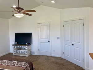 Carpeted bedroom with lofted ceiling, a closet, and ceiling fan