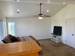 Living room with ceiling fan, a textured ceiling, carpet flooring, and vaulted ceiling