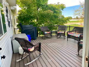 Wooden terrace featuring a grill