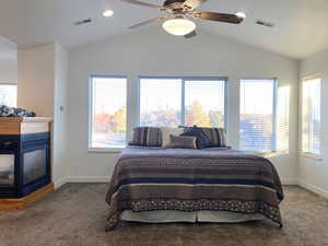 Bedroom with ceiling fan, lofted ceiling, carpet, and multiple windows